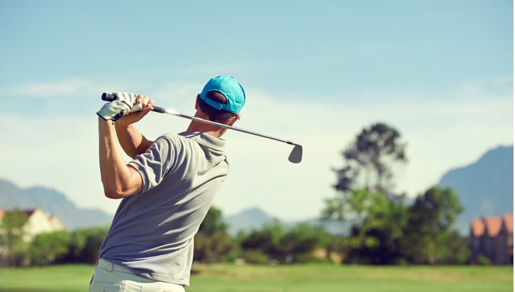 Man playing golf showing proper form of elbow on backswing to prevent in an effort to prevent golfer's elbow.