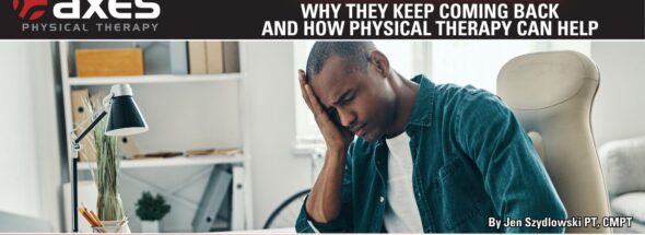 Person sitting at a desk holding their head due to a tension headache while working