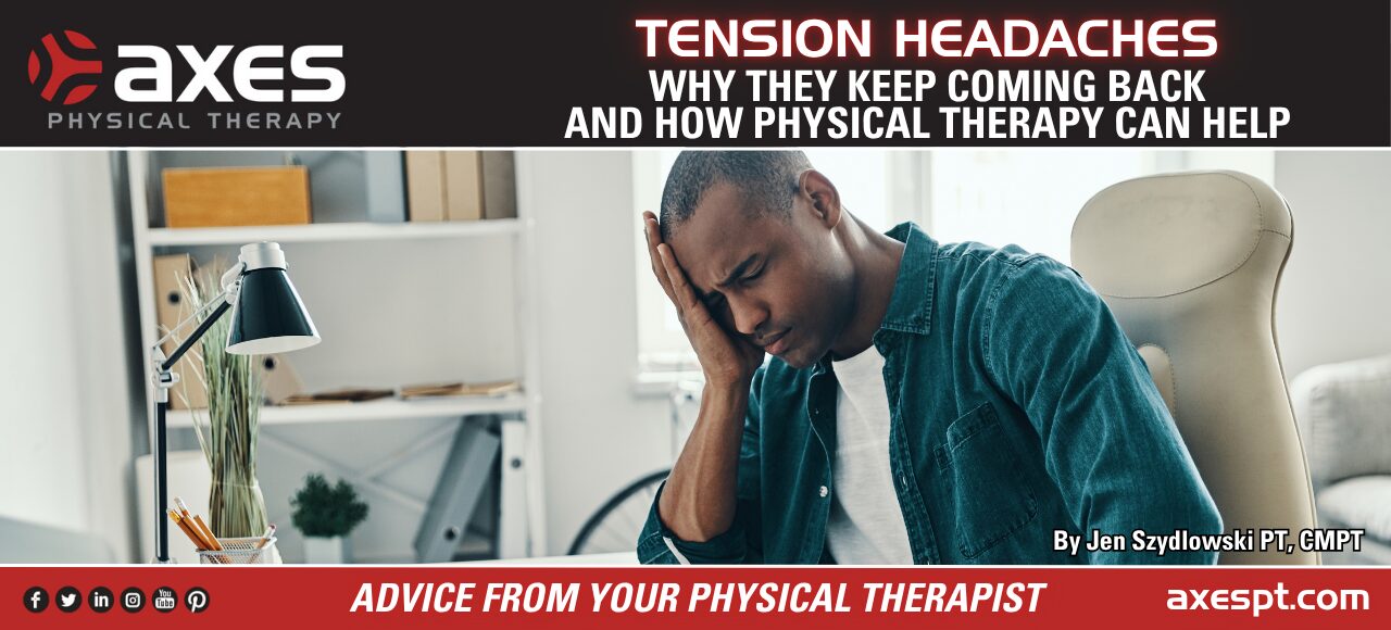 Person sitting at a desk holding their head due to a tension headache while working